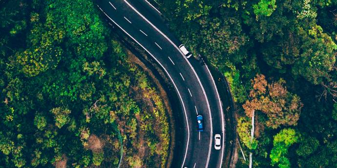 looking down on road winding through trees