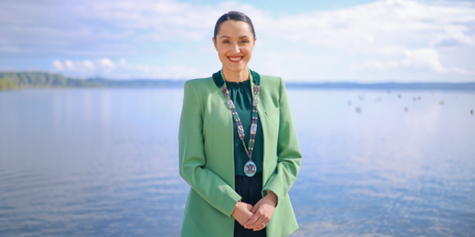 Mayor Tapsell in green standing on a beach