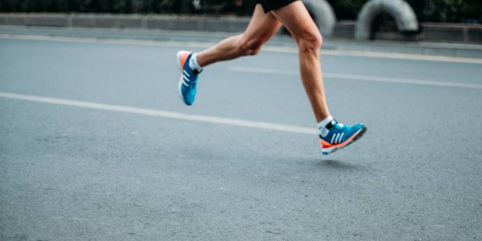 Man running in a marathon, view of his legs and feet