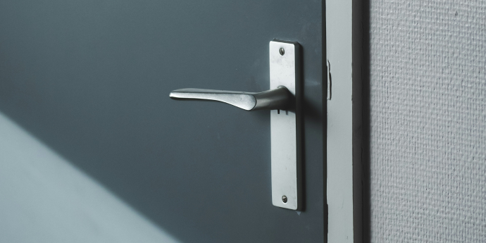 Close up of a door handle on blue door