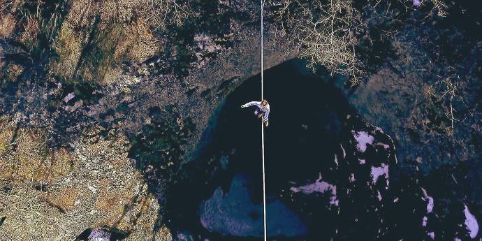 Man on a tightrope over a ravine